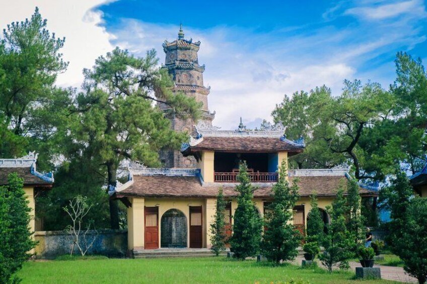 A traditional building with a pagoda-like tower, surrounded by trees and a well-maintained lawn. 3
