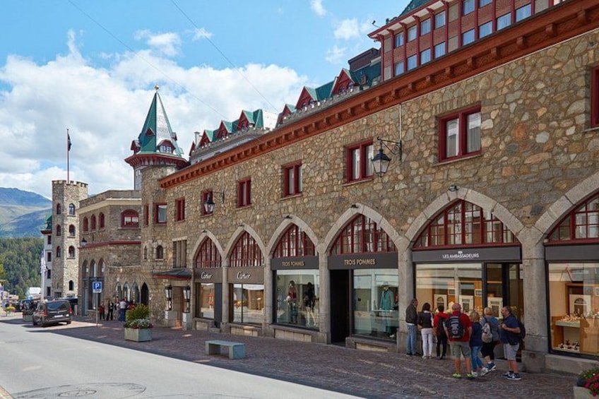 A historic stone building with arched windows and a tower. 4