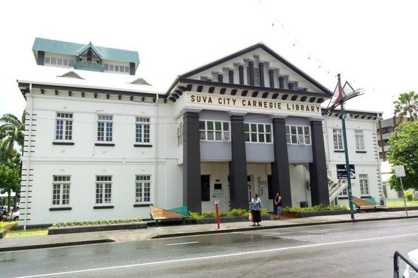 The Suva City Carnegie Library building with a prominent entrance and a flag. 5
