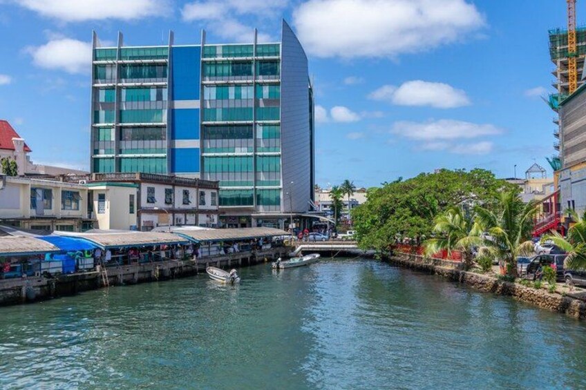 Een waterkant met een modern gebouw, een steiger en een klein bootje. 4