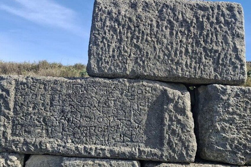 Une pile de gros blocs de pierre à la texture rugueuse, ornés de gravures. 2