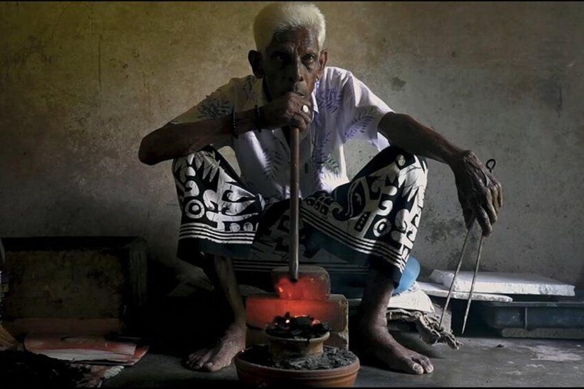 An elderly person sitting on the floor with a pot on fire. 2