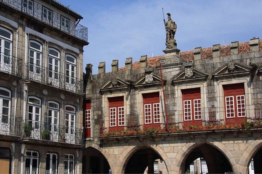 A historic building with red doors and a statue on the roof. 4