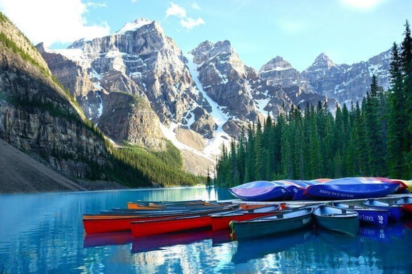 A lake with boats and mountains in the background. 1