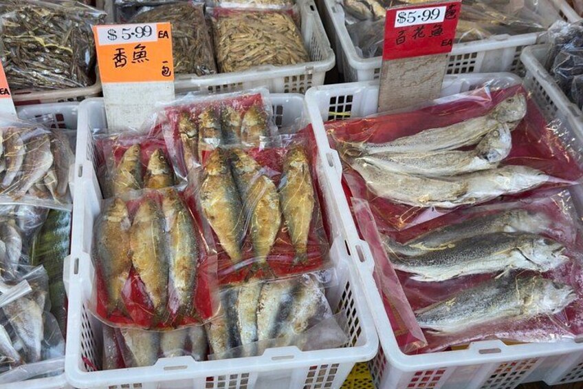Various fish in plastic bins with price tags. 5