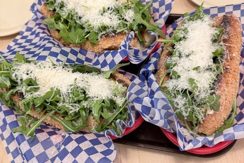 Sandwiches on rye bread with arugula and cheese, served on checkered paper. 2