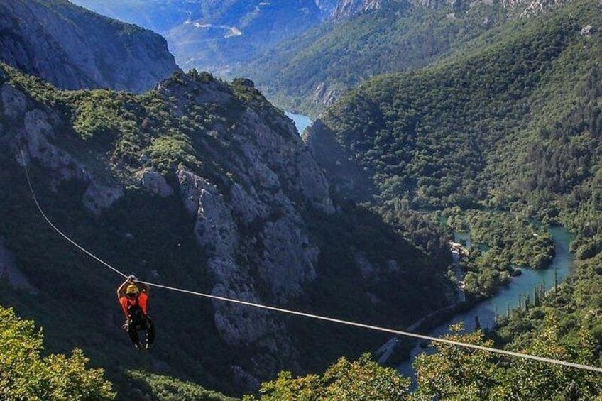A person bungee jumping from a cliff with a river below. 2