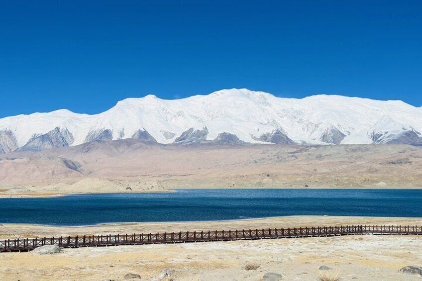 Una cordillera nevada, una masa de agua y un puente de madera. 5