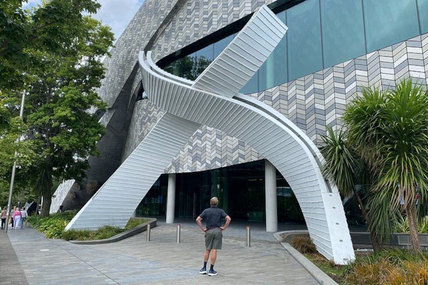 A modern building with a unique curved entrance and a patterned facade. 1
