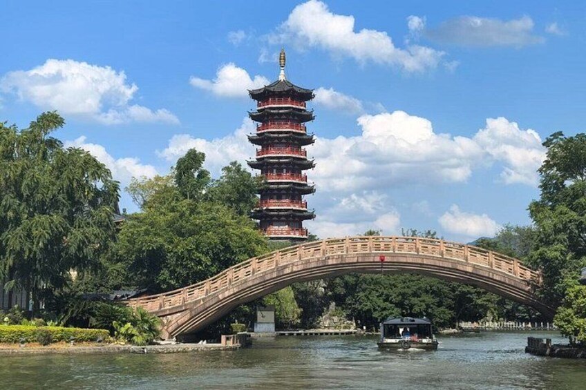 A traditional multi-tiered pagoda, a stone bridge, and a boat on a river. 5