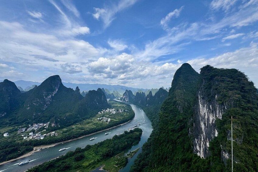 A river winding through a mountainous landscape with dense greenery and rocky cliffs. 1