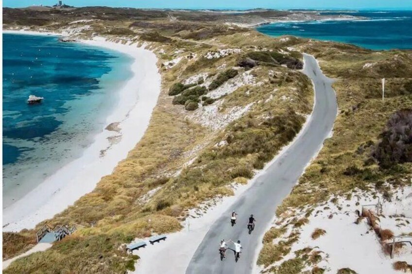 A coastal road winding through a hilly landscape with a beach on one side. 5