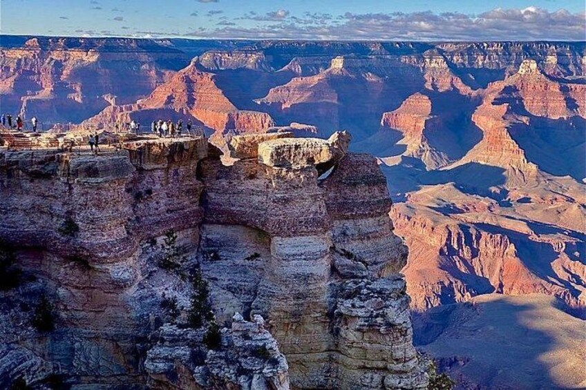 A canyon with a viewing platform and people observing the landscape. 5