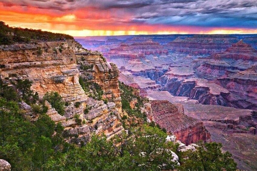 A canyon with layered rock formations and a sunset sky. 1