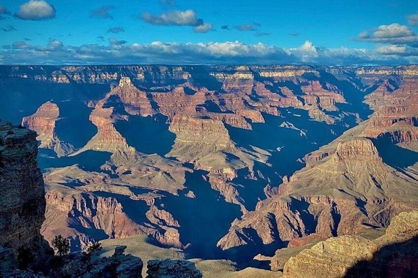 A vast canyon landscape with deep blue river valleys and rugged cliffs. 2