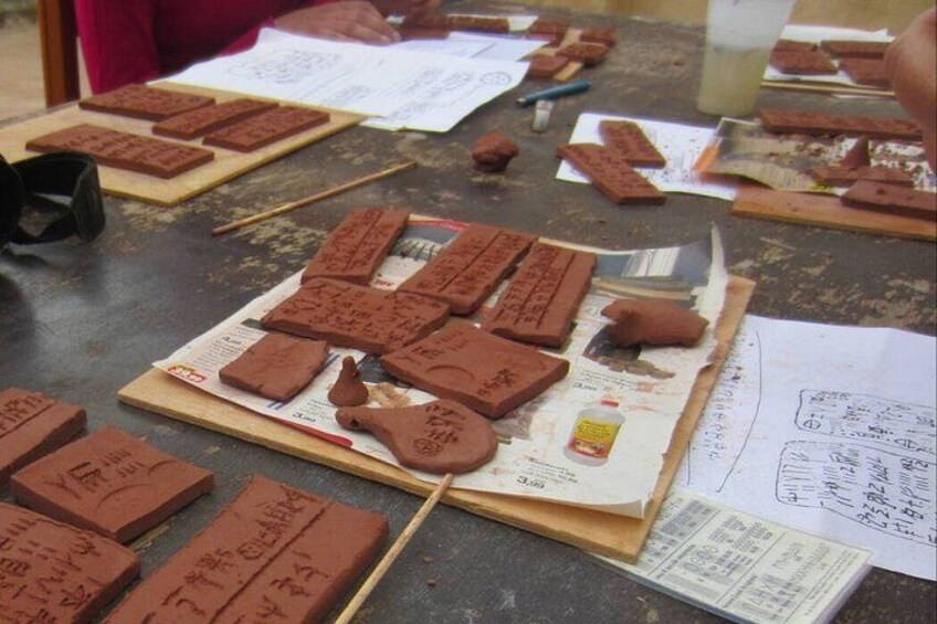 Une table avec différentes sortes de barres de chocolat et des papiers, probablement pour une activité de pâtisserie ou de cuisine. 1