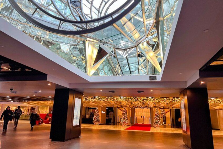 Ein modernes Gebäudeinterieur mit Glasdecke, rotem Teppich und dekorativer Wandgestaltung. 4