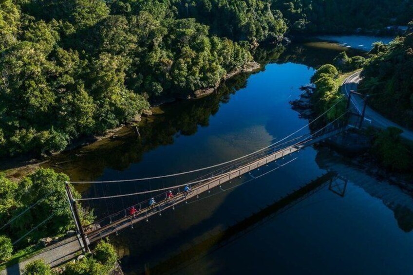 A suspension bridge over a river surrounded by dense forest. 4