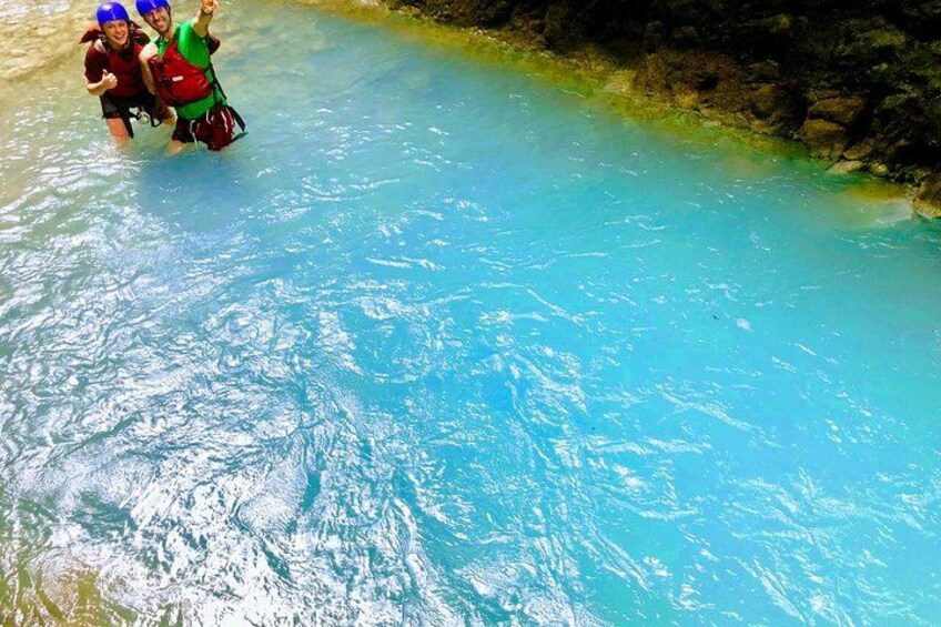 Des personnes se trouvent dans une piscine à l’eau d’un bleu limpide, dont les bords sont rocheux. 3
