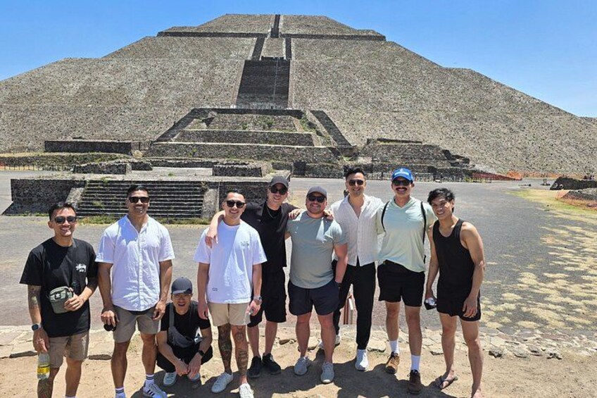 Un gruppo di persone in piedi di fronte a una grande struttura a forma di piramide. 3