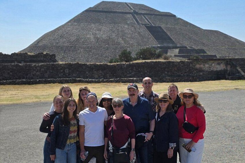 Un gruppo di persone in piedi di fronte a una grande struttura a forma di piramide. 4