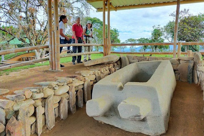 A stone structure with a large basin, surrounded by a stone wall and a wooden fence. 4