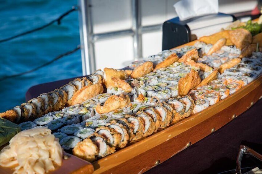 A sushi platter with various types of sushi on a wooden table. 2