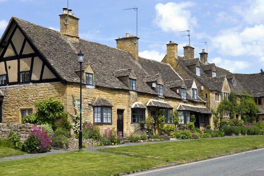 A row of traditional stone houses with pitched roofs and black timber framing. 2