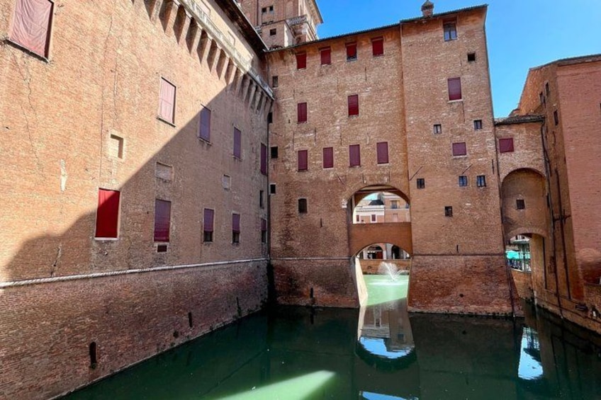 A historic building with arched windows and a canal. 3