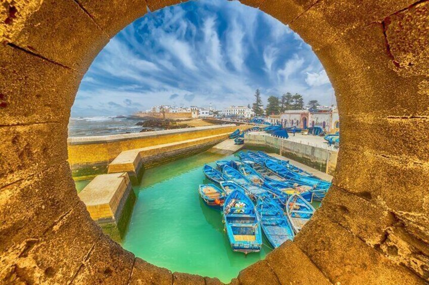 A circular view of a harbor with boats docked and a stone wall in the foreground. 3