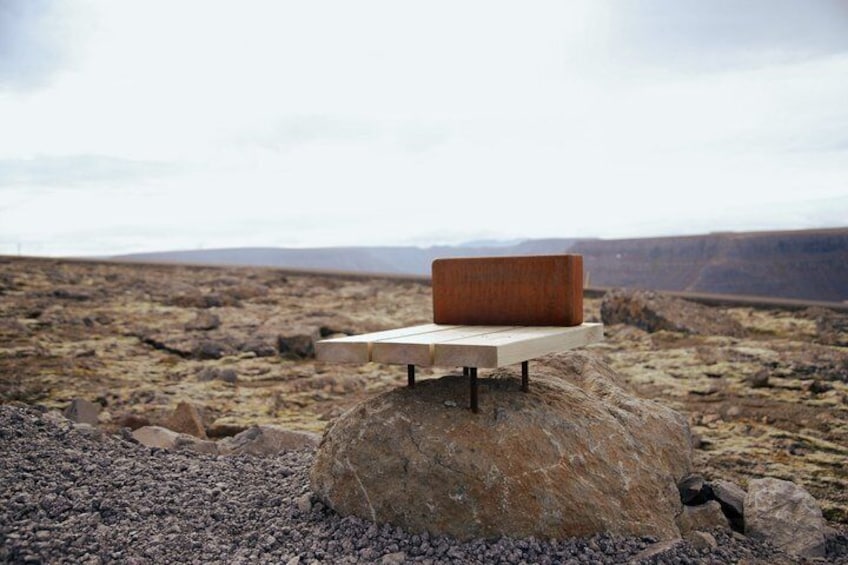 A wooden bench on a rock in a barren landscape. 3