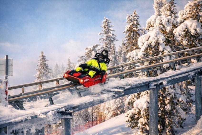 A person sledding down a snowy slope on a red sled. 1
