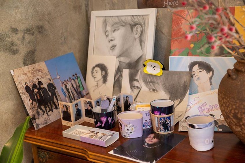 A collection of photographs, mugs, and a vase on a wooden table. 1