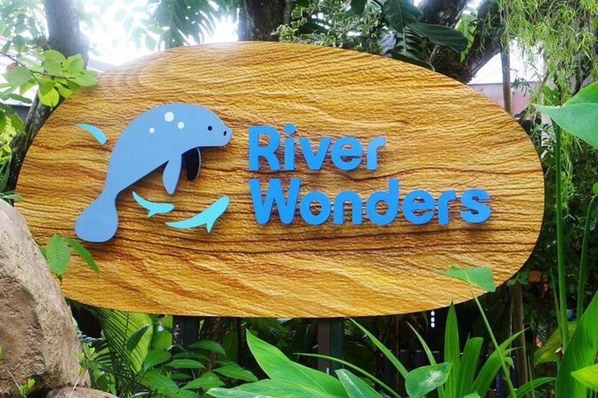 Un panneau en bois représentant un dauphin et portant l’inscription « River Wonders » en bleu. 3