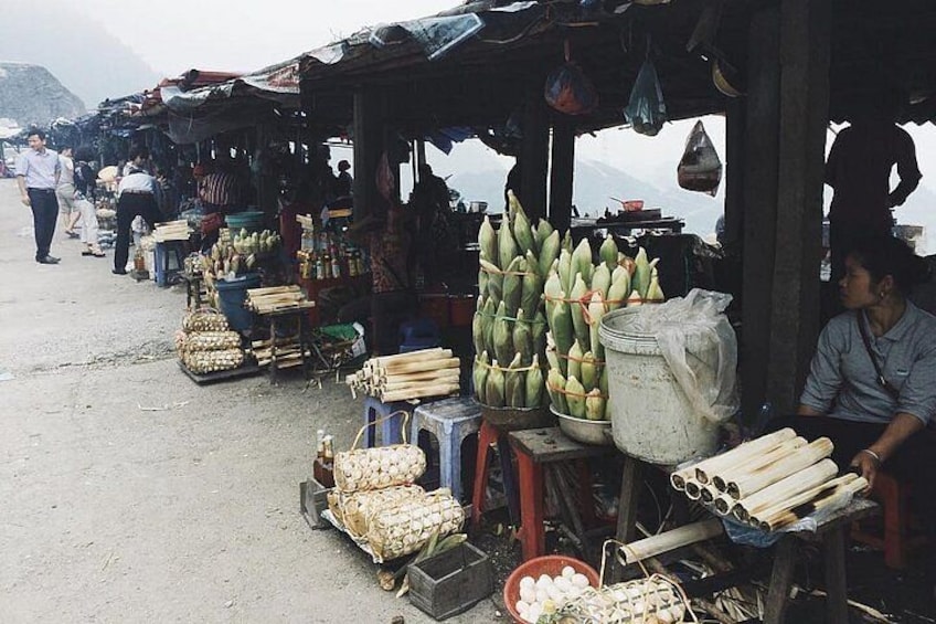 A market with various goods like bananas and vegetables displayed under makeshift stalls. 3
