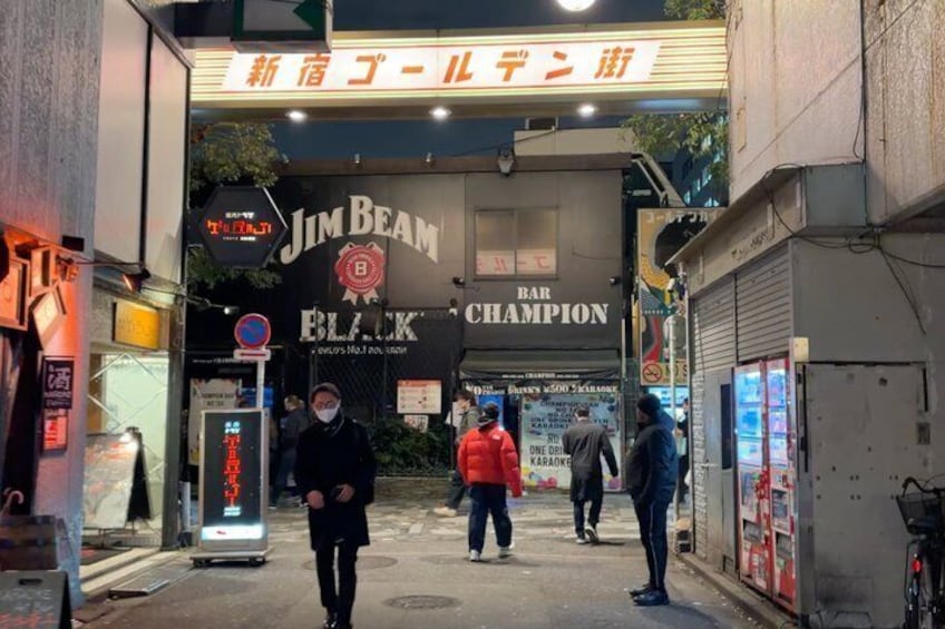 A street with a bar named 'Jim Beam Black Champion' and a sign above it. 2
