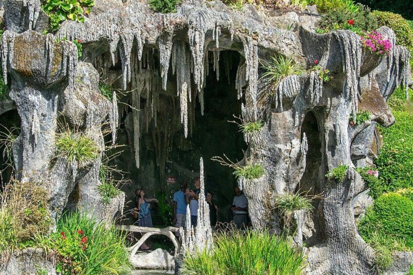 A cave-like structure with icicles and vegetation. 2