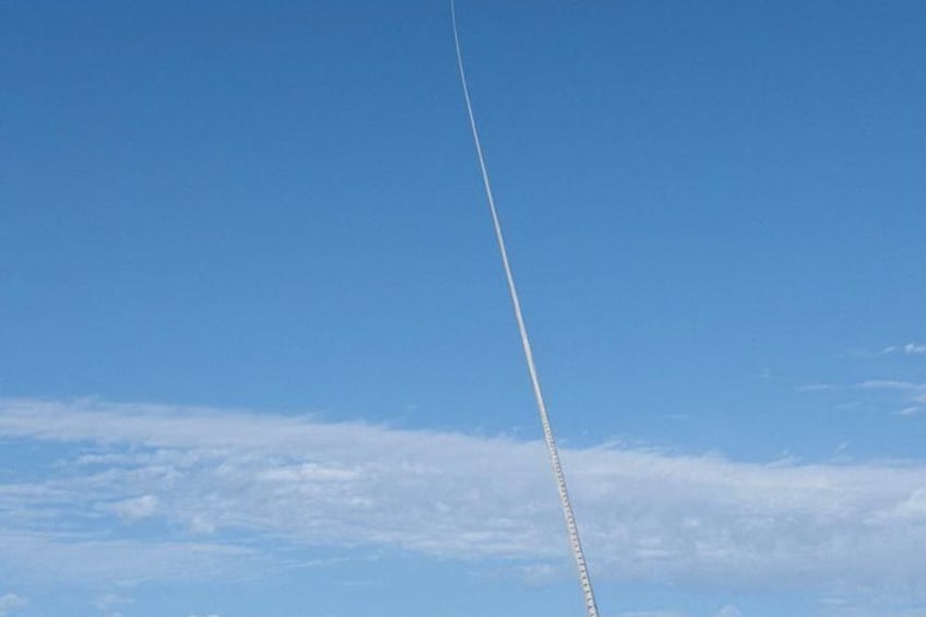 A clear blue sky with a contrail from an airplane. 4