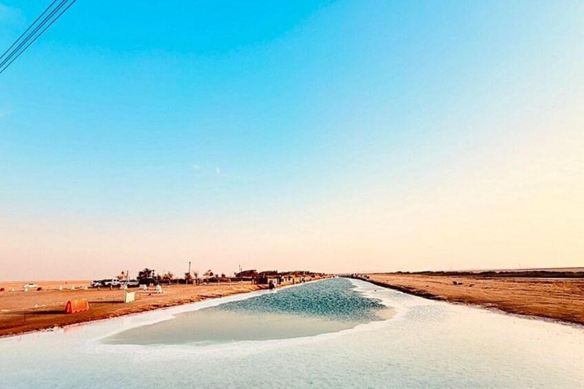 Un paysage côtier caractérisé par un ciel dégagé, une plage de sable et une étendue d’eau. 2