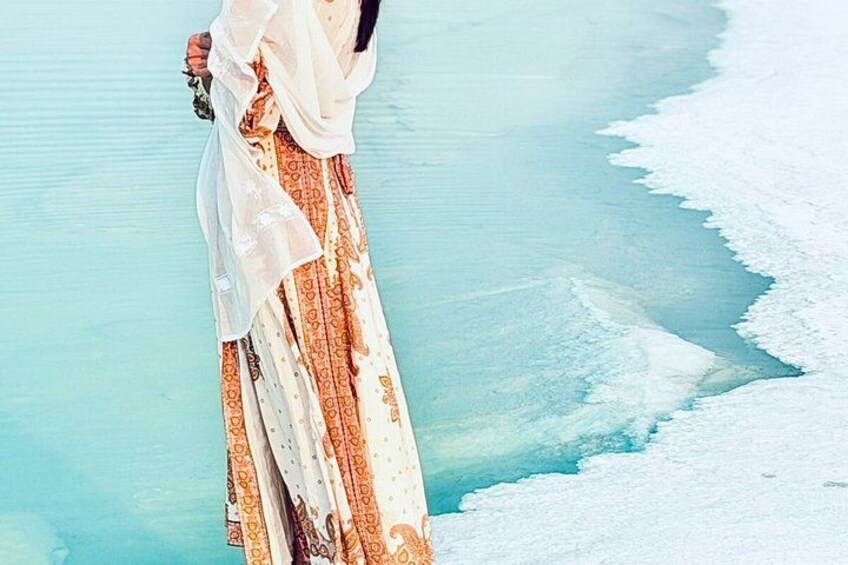 Une personne portant une robe à motifs, debout près d’une étendue d’eau. 3