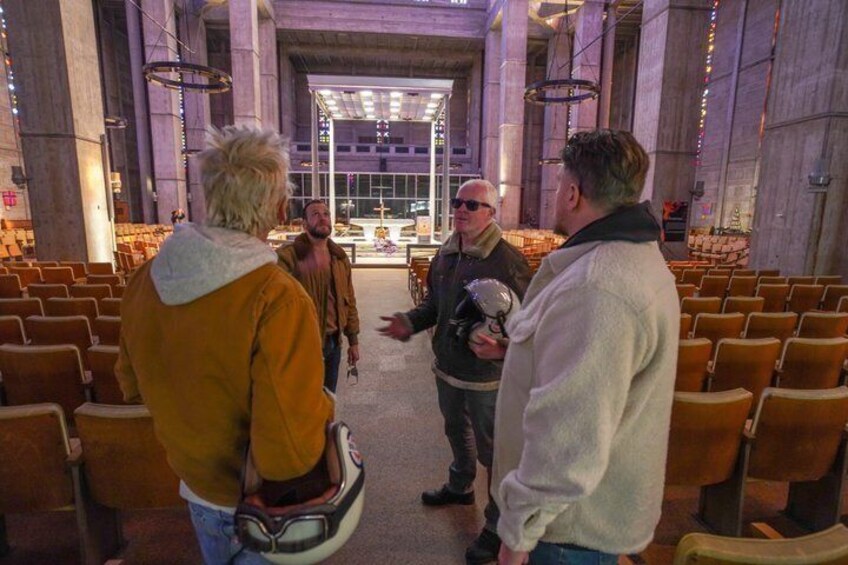 Interior de iglesia con filas de sillas y un altar central. 4