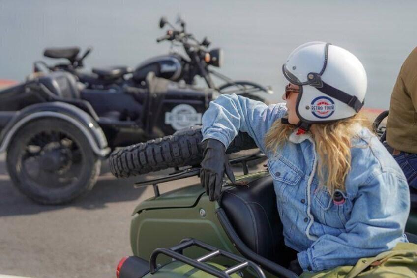 Una persona con chaqueta vaquera y casco en una motocicleta triciclo. 1