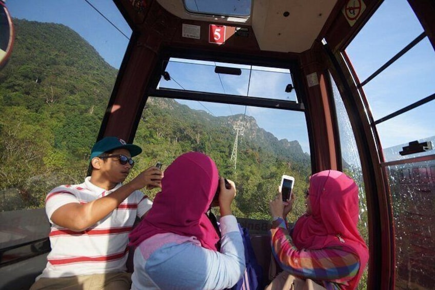 Passengers on a cable car with a mountainous landscape in the background. 3
