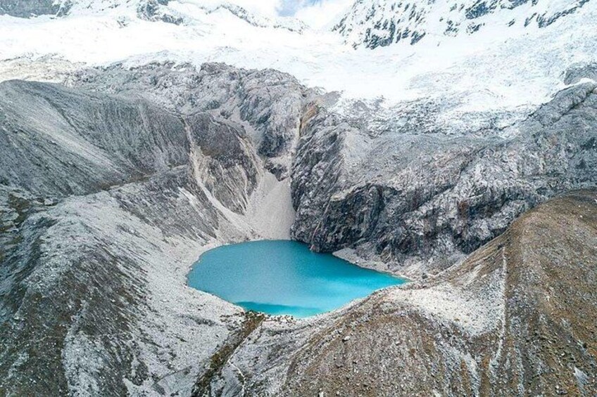 A crater lake surrounded by snow-covered mountains. 4