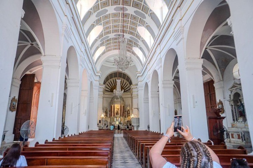 A church interior with arched ceilings, wooden pews, and a central altar. 4