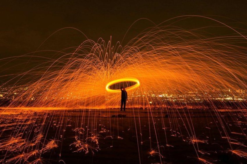 A person performing fire spinning with a glowing ring. 4