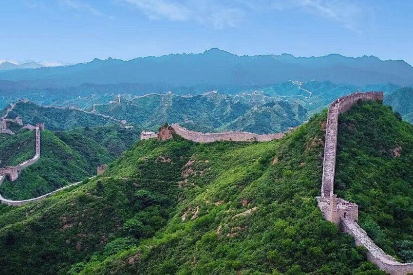 The Great Wall of China winding through lush green hills. 3