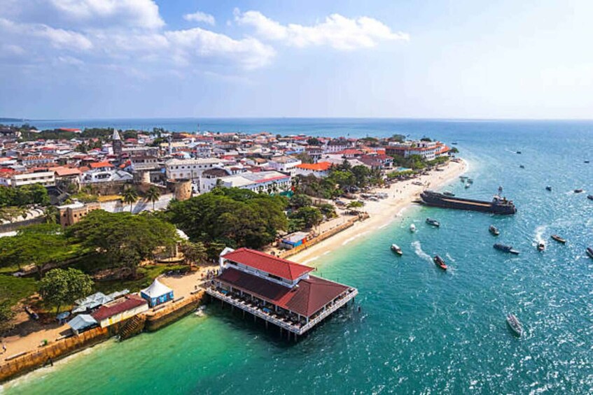 A coastal town with a pier, boats, and a beach. 3