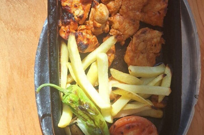 En måltid som består av grillad kyckling, pommes frites och en portion grönsaker. 2