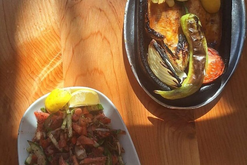 Une table en bois sur laquelle se trouvent une assiette de légumes grillés et un saladier de salade. 3